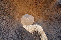 "Porthole" window carved through granite rocks by wind, weather and sea erosion. Campomoro Point, near Propriano, Corsica, France, June 2010.