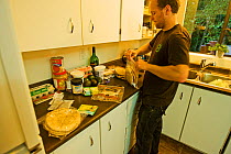 A man preparing food for hiking the West Coast Trail. Pacific Rim National Park, Vancouver Island, Canada, September.