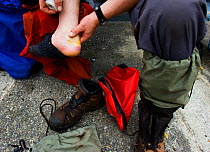 A person massaging a blistered and bruised foot. The West Coast Trail, Pacific Rim National Park, Vancouver Island, Canada, September.