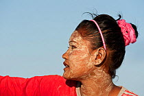 A young Bajau woman with burak (face makeup), a paste made from pounded rice and tumeric which also serves as a natural sunblock. Wearing burak signifies the young lady is single and available for mar...