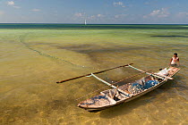 Man setting his gill net in the shallows around Tomia Island. Wakatobi, Sulawesi, Indonesia, November 2009.