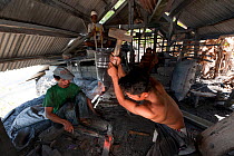 Famous Binongko tukangbesi (blacksmiths) forging machetes from spring steel. Wakatobi, Sulawesi, Indonesia, November 2009.