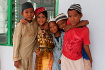 Muslim boys in their prayer clothing outside the mosque in Binongko. Wakatobi, Sulawesi, Indonesia, November 2009.