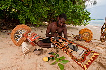 Papua New Guinean artist carving Malagan wooden sculptures, the ceremonial art of New Ireland's living culture, from the soft, abundant Saba tree wood. He uses four natural pigments for paint.  Kavien...