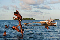 Island children playing in the sea after school. They spend the whole time there until it gets dark and are called home for dinner. M'buke Island, New Ireland, Papua New Guinea, June 2010.