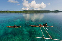 Papua New Guinean islanders paddling their dugout canoes to trade fresh vegetables. They will come back with instant noodles, rice, soap and other groceries they would normally have no access to. Papu...
