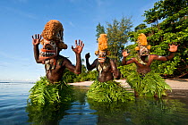 Men dancing in a Tatanua Masks, an image of the soul of the deceased. When a person dies, by Malagan tradition people dance in the shallow waters to try to drive evil spirits or taboos of the dead awa...