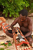 Papua New Guinean artist carving Malagan wooden sculptures, the ceremonial art of New Ireland's living culture, from the soft, abundant Saba tree wood. He uses four natural pigments for paint. Kavieng...