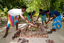Lissenung Island Resort girls preparing a traditional mumu cooking. Kavieng, Papua New Guinea, June 2010.
