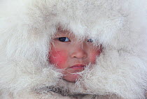 Nenya Vanuito, a young Nenets girl, wearing a traditional hat with fur trim at a winter camp near Tambey. Yamal Peninsula, Western Siberia, Russia. March 2011