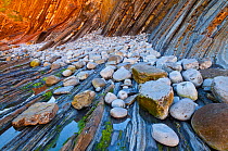 Rocks / pebbles and Flysch - a sequence of sedimentary rocks. Sakoneta beach, Deva, Gipuzkoa, The Bay of Biscay, Spain, June.