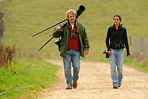 Photographer David Tipling and Young Champion Shabana Shaffick-Richardson carrying photo equipment at Rutland Water, on location for 2020 Vision, Rutland, UK, April 2011. Model released