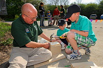 Osprey Project Information Officer, Paul Stammers, building bird boxes with children during an event at the Lyndon Visitor Centre, Rutland Water, Rutland, UK, April 2011