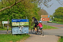 Cyclists, adult and child on double bicycle at Lyndon Visitor Centre, Rutland Water, Rutland, UK, April 2011
