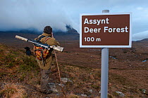 Don o'Driscoll, of the John Muir Trust, with spoof Deer Forest sign, Quinag, Sutherland, Highland, Scotland, UK, January 2011