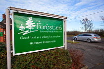Green pub sign beside road in The National Forest, Moira, Derbyshire, UK, November 2011