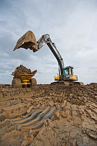 Wetland habitat ecosytem creation for the RSPB by Breheny Civil Engineers at Bowers Marsh RSPB Reserve, Thames Estuary, Essex, UK. November 2011. Heavy earth excavator removes clay for future replacem...