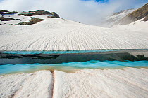 Ice melt pool in snow near the peak of La Munia Circo. The Pyrenees, Aragon, Spain, May 2011.
