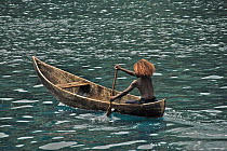 Young girl paddling dugout canoe, Peava village, Solomon Islands, Melanesia, September 2008.