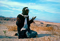 Bedouin man praying to Allah in the desert, Sinai desert, Egypt