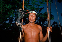 Matses tribesman with dead Piping guan (Aburria pipile) killed in the Amazon rainforest with his bow and arrow, Matses Indians, Amazonia, Peru, November 2005