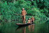 Matses indians hunting for birds in a handmade dug out canoe with bows and arrows, Amazonia, Peru, November 2005.