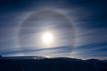 Sun Dog, or Parhelion, caused by refraction of the sun's rays, more commonly seen in Antarctica, above glacier, Dry Valleys, Antarctica, December 2009. Taken on location for the BBC series, Frozen Pla...