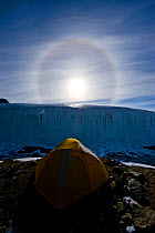 Sun Dog, or Parhelion, visible over tent of film crew, caused by refraction of the sun's rays, more commonly seen in Antarctica, above glacier, Dry Valleys, Antarctica, December 2009. Taken on locatio...