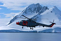 Royal Navy helicopter from HMS Endurance flying over sea and antarctic landscape, November 2008,  Taken on location for the BBC series, Frozen Planet.