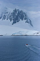 Aerial view of film crew in small boat approaching land, Antarctica, November 2008,  Taken on location for the BBC series, Frozen Planet.