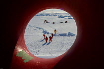 View through the porthole of science teams and Frozen Planet film crew working on the sea ice in the Bering Sea, Alaska, USA, March 2008. The film crew were in search of Spectacled eider ducks, temper...