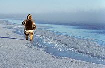 Inuit man dressed in Reindeer / Caribou skin clothing while hunting at the floe edge. Igloolik, Nunavut, Canada, 1990. 40 BELOW bookplate.