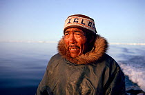 Inuit hunter steering his boat while Walrus hunting in Summer. Igloolik, Nunavut, Canada, 1992. 40 BELOW bookplate.
