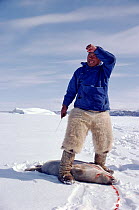 Inuit hunter skinning seal, Northwest Greenland, 1980. 40 BELOW bookplate.