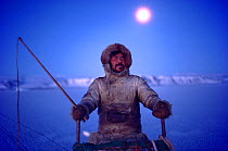 Inuit hunter travelling by dog sled during the polar night. Northwest Greenland, 1987. 40 BELOW bookplate.