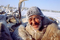 Dolgan herder covered in frost while working with his Reindeer / Caribou (Rangifer tarandus) during winter. Taymyr, Northern Siberia, Russia. 40 BELOW bookplate.