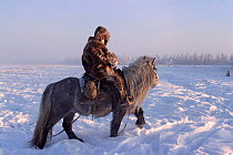 Yakut herder riding Horse (Equus caballus) in the winter near Verkhoyansk. Yakutia, Siberia, Russia, 1999. 40 BELOW bookplate.