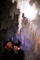Cameraman Gavin Thurston filming ice crystals under volcanic ice cave, Mount Erebus, Antarctica. Due to delicate nature of the crystals Gavin used video function on SLR camera. Taken on location for B...