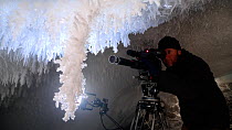 Cameraman Gavin Thurston filming ice crystals under volcanic ice cave, Mount Erebus, Antarctica. Taken on location for BBC Frozen Planet series, 2009