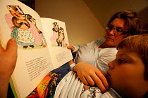 Mother and son, reading story book about badger badger family. Black Forest, Germany. Model released