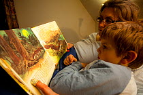 Mother and son, reading story book about foxes. Black Forest, Germany.