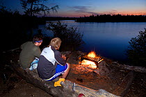 Two campers watching the sunset from campsight at Little Saganaga Lake in the Boundary Waters Canoe Area Wilderness, Minnesota, USA, Model released