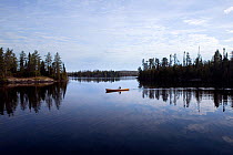 Canoe on Little Saganaga Lake in the Boundary Waters Canoe Area Wilderness at dawn, Minnesota, USA, Model released