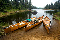 Three canoes pulled up on the shore in the Boundary Waters Canoe Area Wilderness, Minnesota, USA, May 2010
