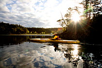 Kayaker in a bydarka style boat exploring the waters of Garrison Bay San Juan Island, Washington, USA, May 2009