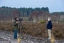 Will Bolton filming interview with RSPB's Mel Kemp on Westleton Heath, Sandlings heath, Suffolk, UK,  February 2011