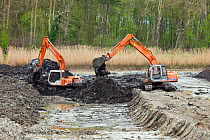 Excavators restoring peat bog after peat extraction, Westhay Moor SWT reserve, Somerset Levels, Somerset, England, UK, April 2011