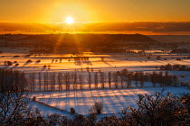 Winter sunset over the Somerset Levels from Walton Hill on a misty evening with snow on the ground. View includes Butleigh Moor, Somerton Moor, Street Moor, Low Ham Moor, Walton Moor, Pitney Moor, Hui...