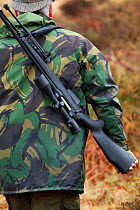 Man carrying gun, deer stalking, Assynt Foundation, Glencansip Estate, Assynt, Sutherland, NW Scotland, UK, January 2011. Model released