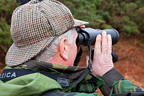 Deer stalker scanning for deer with binoculars, Assynt Foundation, Glencansip Estate, Assynt, Sutherland, NW Scotland, UK, January 2011. Model released